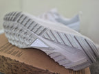 A close-up of a white Nike sneaker showing its textured gray and white outsole.