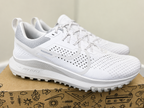A pair of Nike running shoes in white and light gray, displayed on a brown cardboard box with hand-drawn doodles on a light beige background.